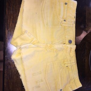 Mustard yellow shorts cut offs and holes